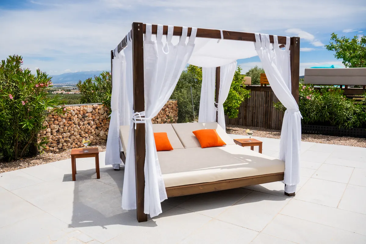 Cama Balinesa Conífera de madera tratada con cortinas blancas para jardín, terraza o piscina.