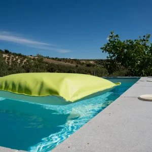 Puff Tomasso Flotante para piscina con relleno adaptable y tapicería exterior resistente.