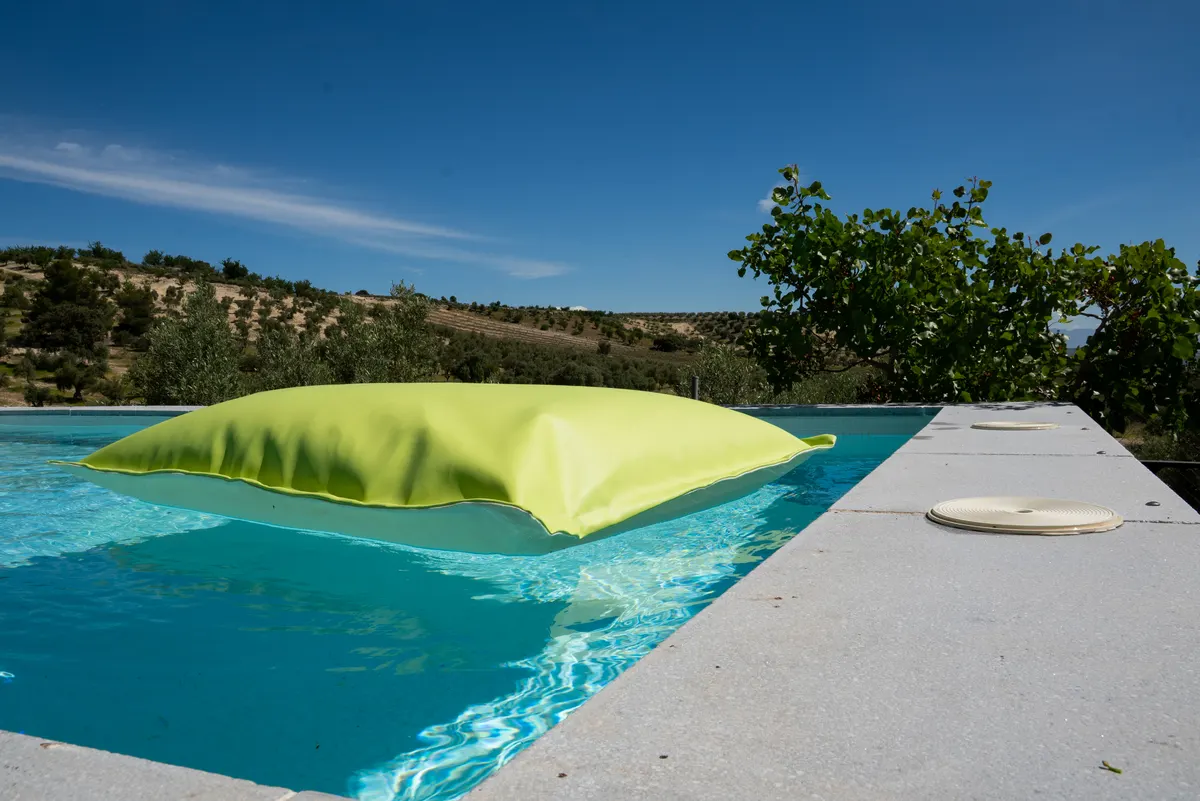 Puff Tomasso Flotante para piscina con relleno adaptable y tapicería exterior resistente.
